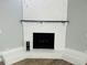 Close up of the painted white brick fireplace with a black mantle and hearth at 412 Editha Cir, Sanford, FL 32771