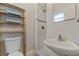 A clean, tiled bathroom includes a shower, a toilet, a small sink and a wood shelf at 417 Carvell Dr, Winter Park, FL 32792