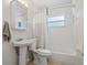 A white-tiled bathroom features a vanity, toilet and shower-tub combination with a white shower curtain at 417 Carvell Dr, Winter Park, FL 32792