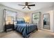 This bedroom features a ceiling fan, neutral walls and decor, two windows, and a black metal bed frame at 417 Carvell Dr, Winter Park, FL 32792