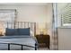 Close up on a neatly made bed featuring a black metal frame and two comfy blue pillows atop matching comforter at 417 Carvell Dr, Winter Park, FL 32792