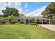 Inviting single-story home with lush green lawn and covered porch, featuring a striking blue front door at 417 Carvell Dr, Winter Park, FL 32792