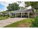 Home exterior featuring a covered porch, well-kept lawn, and landscaped front yard in a beautiful neighborhood at 417 Carvell Dr, Winter Park, FL 32792
