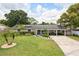 Charming single-story home featuring a well-manicured lawn and a welcoming front porch with blue door at 417 Carvell Dr, Winter Park, FL 32792