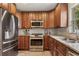 A kitchen boasting stainless steel appliances, wooden cabinetry, and tiled backsplash at 417 Carvell Dr, Winter Park, FL 32792