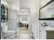 Bright bathroom with double vanity, glass enclosed shower and view into main bedroom at 417 Carvell Dr, Winter Park, FL 32792