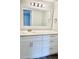 Modern bathroom vanity with white cabinets, stone countertop, and decorative lighting at 4225 Thornbriar Ln # 305, Orlando, FL 32822