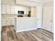 Modern kitchen with white cabinets, stainless microwave and a breakfast bar overlooking the living area at 4225 Thornbriar Ln # 305, Orlando, FL 32822