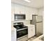 Modern kitchen with white cabinets, stainless microwave, oven, and refrigerator appliances at 4225 Thornbriar Ln # 305, Orlando, FL 32822
