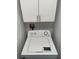 Laundry area featuring a washing machine, upper storage cabinets, and water connections at 4225 Thornbriar Ln # 305, Orlando, FL 32822