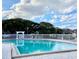 Community pool with clear blue water, lounge chairs, and surrounding landscaping at 4225 Thornbriar Ln # 305, Orlando, FL 32822