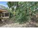 View of an overgrown backyard with a detached garage accessible by wooden stairs in a partially wooded area at 448 Sundown Trl, Casselberry, FL 32707