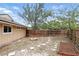 Fenced backyard featuring garden beds, a wooden gate, and stepping stones set under a bright blue sky at 448 Sundown Trl, Casselberry, FL 32707