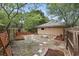 Landscaped backyard with wooden fencing, raised garden beds, stepping stones, and a fire pit area at 448 Sundown Trl, Casselberry, FL 32707