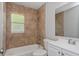 Updated bathroom featuring a tub with tile surround, white vanity, and toilet at 4739 Elkmont Rd, Orlando, FL 32808