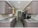 Updated galley kitchen features gray cabinets, granite counters, and stainless appliances at 4739 Elkmont Rd, Orlando, FL 32808