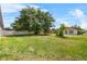 View of the spacious backyard with mature trees and white privacy fence at 504 Delido Way, Kissimmee, FL 34758
