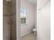 Tiled bathroom with a window and shower featuring sleek fixtures and tile at 504 Delido Way, Kissimmee, FL 34758