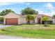 Charming single-story home with a well-maintained lawn, lovely palm trees, and two-car garage at 504 Delido Way, Kissimmee, FL 34758