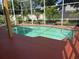 Screened-in pool with a red concrete deck and lush, green landscaping at 508 Royal Tree Ln, Oviedo, FL 32765
