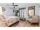 Bedroom with wood-look flooring, ceiling fan, and large window at 5113 Sage Way, Kissimmee, FL 34758