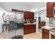Modern kitchen featuring stainless steel appliances, dark wood cabinetry, and tiled floors at 5113 Sage Way, Kissimmee, FL 34758
