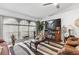 Cozy living room featuring a striped rug, large windows, and a mounted television at 5113 Sage Way, Kissimmee, FL 34758