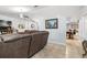Comfortable living room featuring a large sofa, tiled floors, and a decorative painting at 5113 Sage Way, Kissimmee, FL 34758