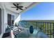 Balcony with blue railings and outdoor seating overlooking a serene green landscape on a clear day at 5300 S Atlantic Ave # 16-505, New Smyrna Beach, FL 32169