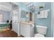 Well-lit bathroom with blue walls, tile flooring, vanity with storage, and a toilet at 5300 S Atlantic Ave # 16-505, New Smyrna Beach, FL 32169