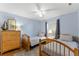 Light and airy bedroom featuring two twin beds, light blue walls, ceiling fan, and wooden furniture at 5300 S Atlantic Ave # 16-505, New Smyrna Beach, FL 32169