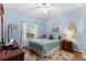 Comfortable bedroom has blue walls, wood-look floors, a ceiling fan, a bed with decorative pillows, and a dresser at 5300 S Atlantic Ave # 16-505, New Smyrna Beach, FL 32169