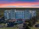 Stunning exterior view of the condo building against a vibrant sunset sky at 5300 S Atlantic Ave # 16-505, New Smyrna Beach, FL 32169