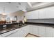 Bright kitchen area with white cabinetry, dark countertops, stainless steel appliances, and neutral tile flooring at 5300 S Atlantic Ave # 16-505, New Smyrna Beach, FL 32169