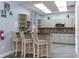 Kitchen with breakfast bar, stainless steel microwave, decorative tile backsplash, and neutral cabinets at 5300 S Atlantic Ave # 16-505, New Smyrna Beach, FL 32169