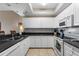 Well-lit kitchen features white cabinetry, tile floors, stainless steel microwave and oven, and stone countertops at 5300 S Atlantic Ave # 16-505, New Smyrna Beach, FL 32169