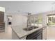 Kitchen island featuring stainless steel sink, granite countertops and view of living area at 540 Seven Oaks Blvd, Winter Springs, FL 32708