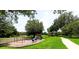 Community playground featuring swings, slides, and a covered picnic area surrounded by mature trees at 540 Seven Oaks Blvd, Winter Springs, FL 32708