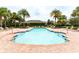 Inviting community pool with clear water, brick surround, lounge chairs, and tropical palm trees at 540 Seven Oaks Blvd, Winter Springs, FL 32708