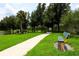Scenic community walking path with lush green grass, mature trees, and a park bench at 540 Seven Oaks Blvd, Winter Springs, FL 32708