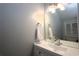 Bathroom with light gray walls, white vanity, large mirror, and a window providing natural light at 613 Casa Park Court B N Ct # B, Winter Springs, FL 32708