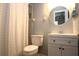 Well-lit bathroom featuring a modern vanity, round mirror, and shower with patterned curtain at 613 Casa Park Court B N Ct # B, Winter Springs, FL 32708