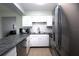Bright kitchen featuring white cabinets, stainless steel appliances, gray counters, and open to the living room at 613 Casa Park Court B N Ct # B, Winter Springs, FL 32708