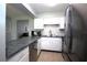 Bright kitchen featuring white cabinets, stainless steel appliances, gray counters, and open to the living room at 613 Casa Park Court B N Ct # B, Winter Springs, FL 32708