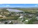 Panoramic aerial view highlighting the property's proximity to a serene lake and the surrounding wooded area at 7017 Bridle Path, St Cloud, FL 34771