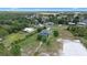 Expansive aerial view of a sprawling property with a pool, mature trees, and a glimpse of the surrounding neighborhood at 7017 Bridle Path, St Cloud, FL 34771