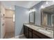Bathroom featuring a double vanity with granite counters and a tiled walk-in shower at 7017 Bridle Path, St Cloud, FL 34771