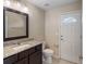 Bathroom featuring granite counters, vanity lighting, and access to exterior at 7017 Bridle Path, St Cloud, FL 34771