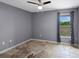 Neutral bedroom featuring tiled floors, ceiling fan, and window with backyard view at 7017 Bridle Path, St Cloud, FL 34771