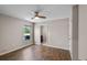 Bright bedroom with wood-look floors, fan, large window and ensuite access at 7017 Bridle Path, St Cloud, FL 34771